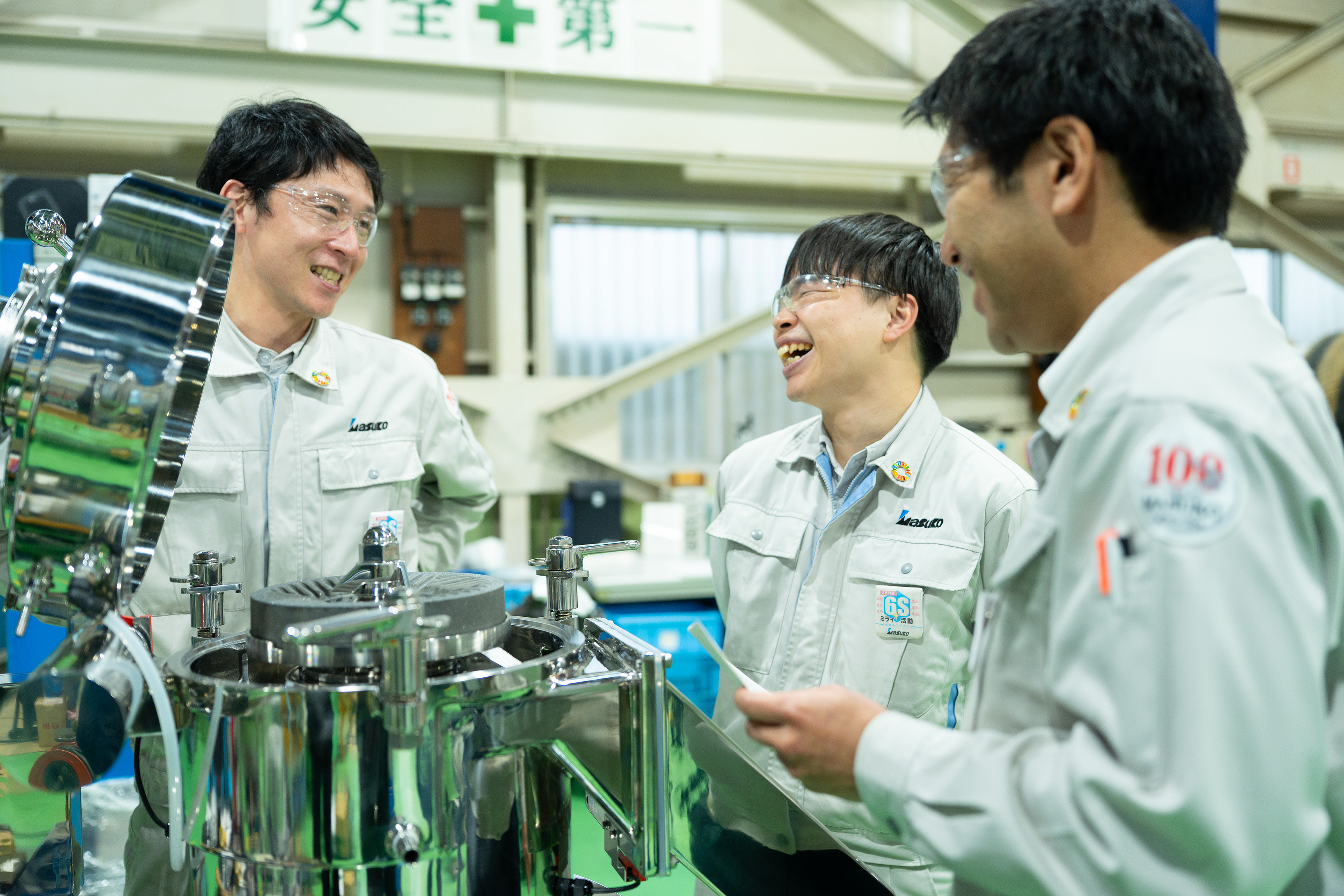 社員が機械を囲んで相談している様子